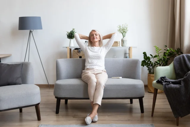 Frau sitzt entspannt auf Sofa